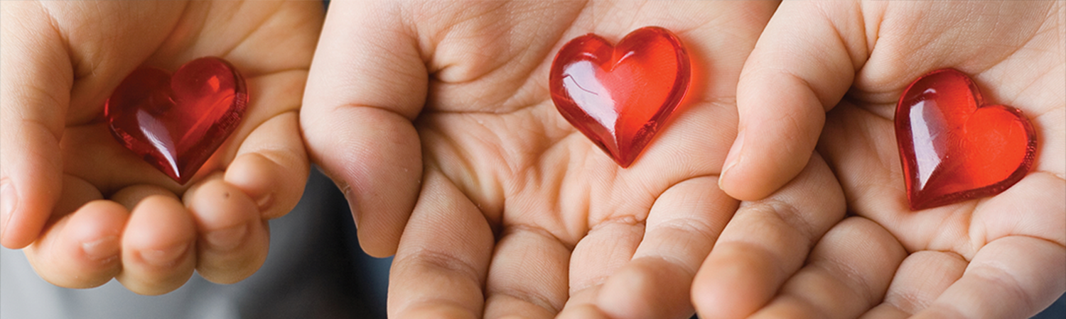 3 child's hands holding glass hearts
